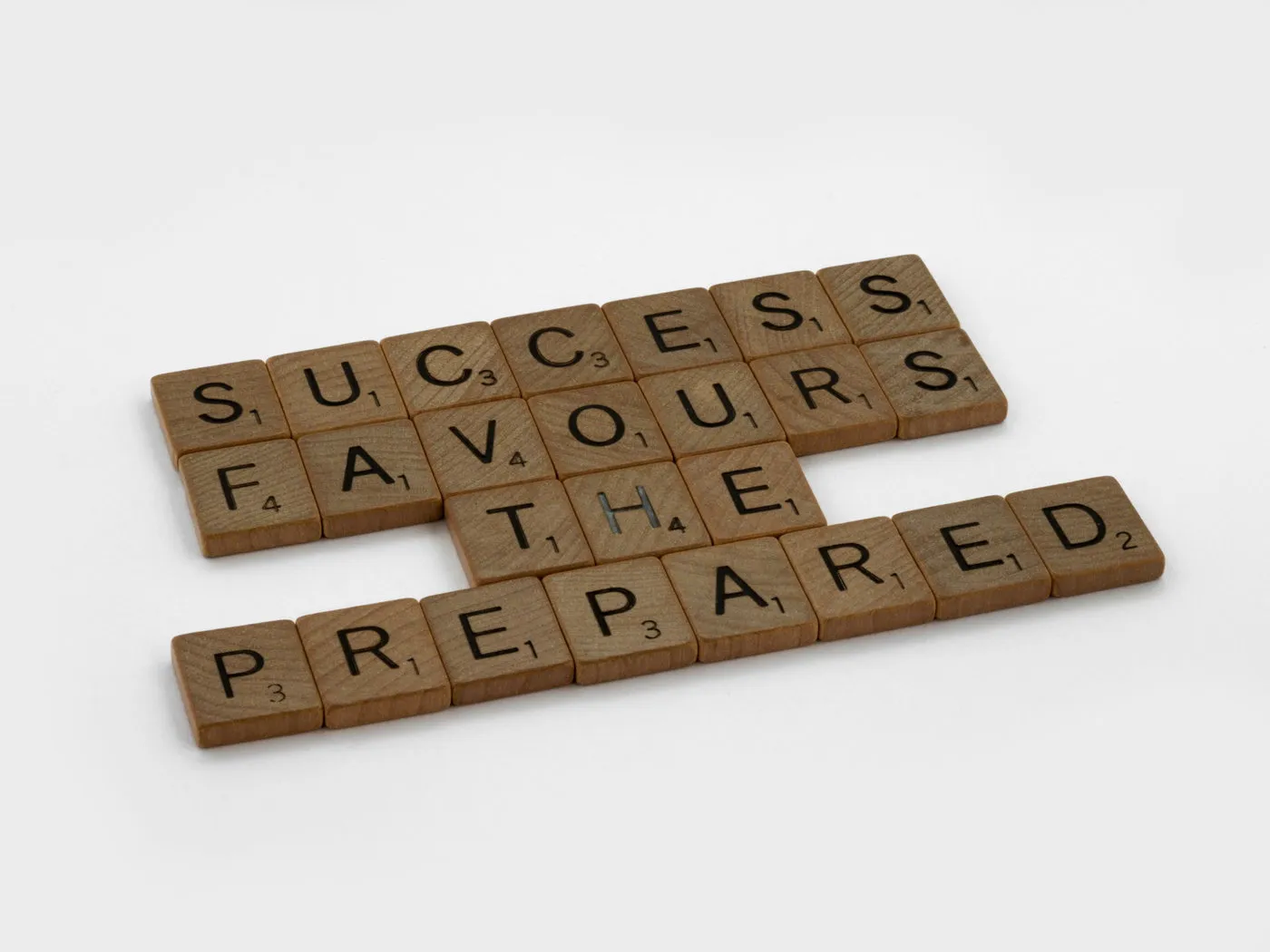 Scrabble-Steine bilden den Satz „Success favours the prepared“
